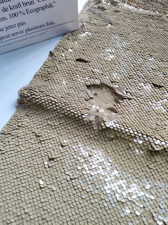 Close‑up detail of mustard reversible spangle fabric, 5mm flip‑able sequins on textile base
